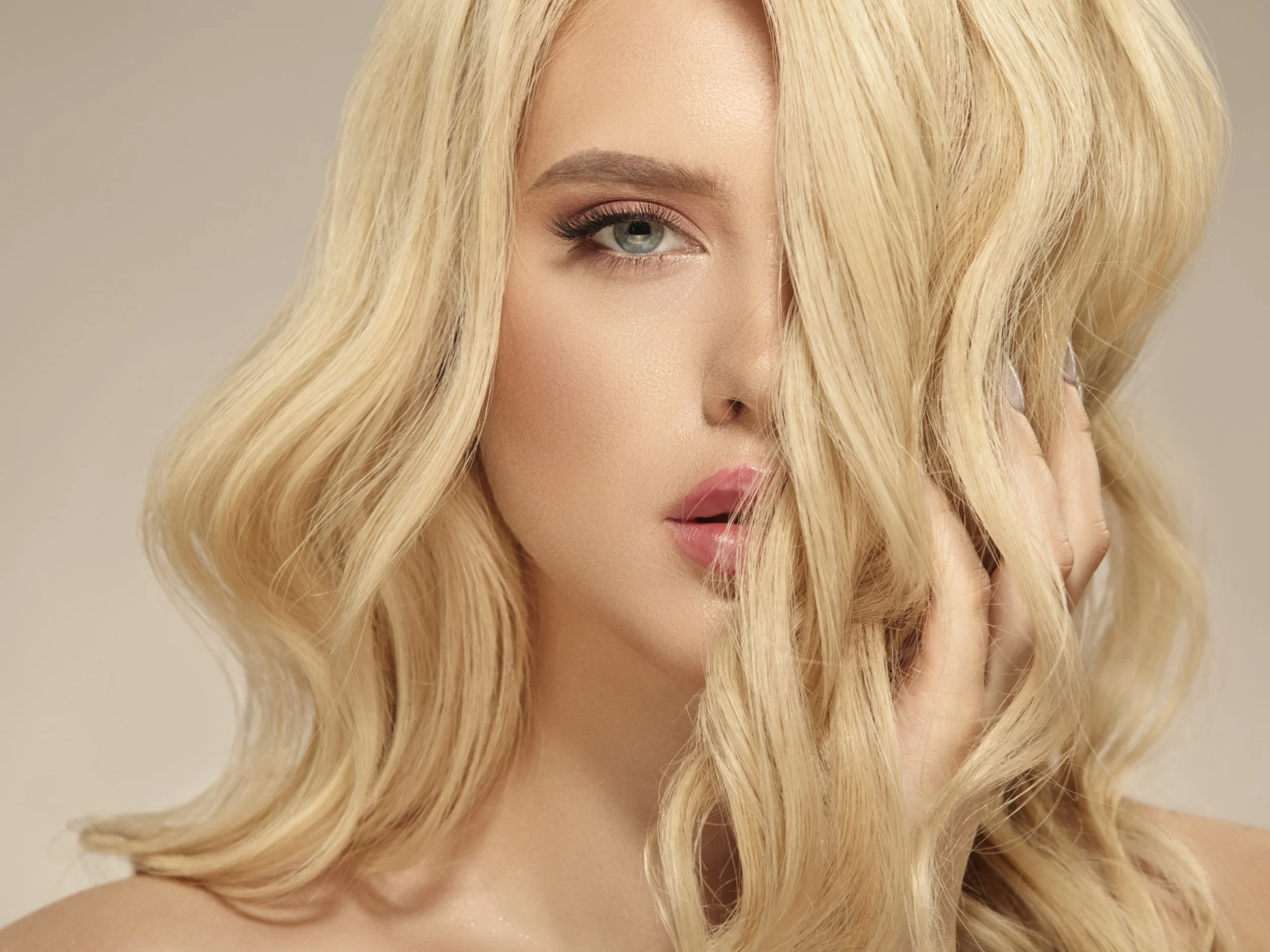 female beauty hairstyle blonde long wavy hair caucasian attractive woman has natural curly hairstyle close up shot beige isolated 1 scaled